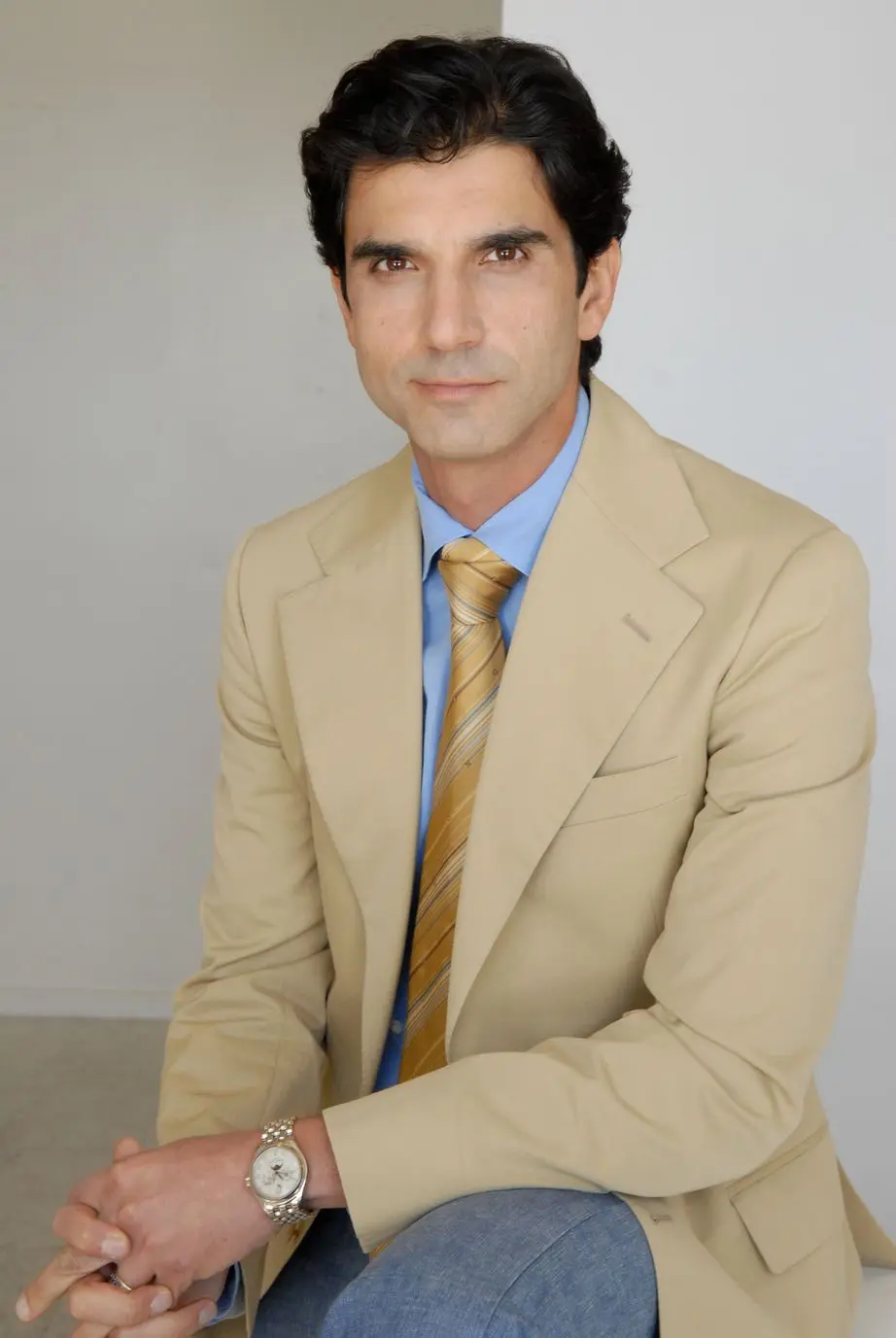 A man in a suit and tie sitting down.