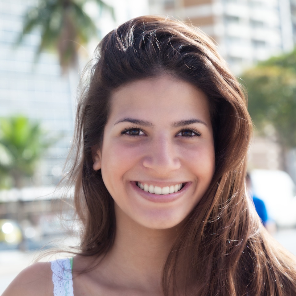Portrait of a laughing woman with dark hair in the city